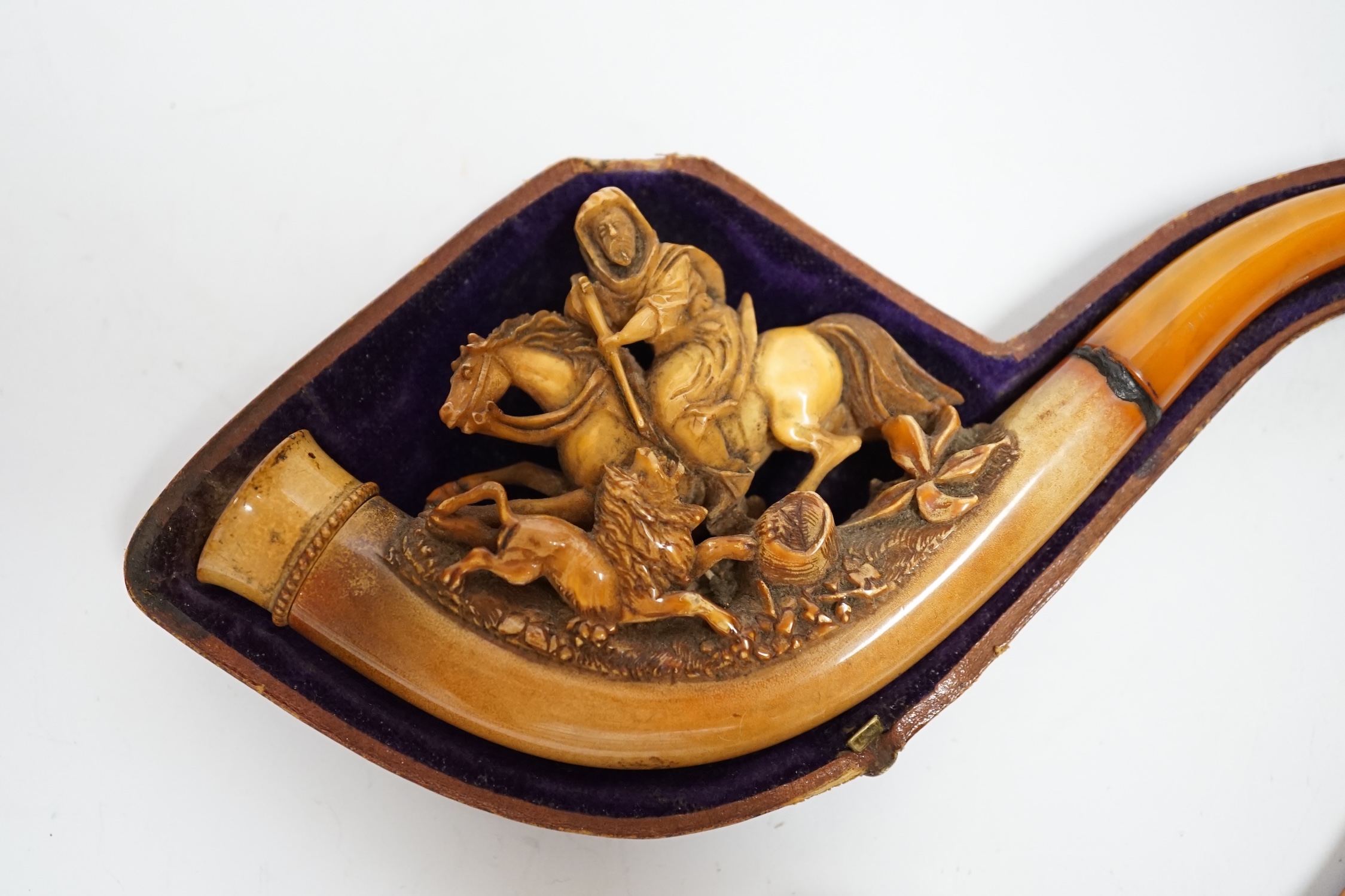 Two carved Meerschaum pipes, one in the form of a huntsman on horseback with amber mouthpiece